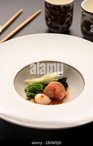 plat japonais de noix de saint-jacques de sashimi avec légumes sur céramique blanche baguettes et tasses modernes Banque D'Images