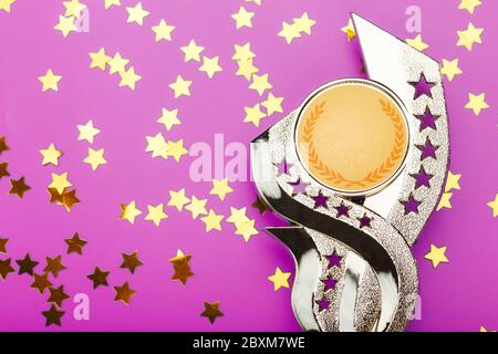 Super-prix doré avec une dispersion d'étoiles sur fond rose. Banque D'Images