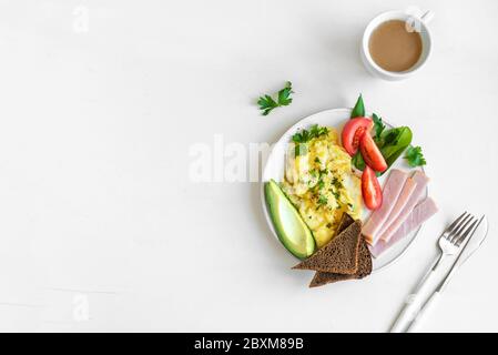 Petit déjeuner sain avec œufs brouillés, jambon, avocat, pain grillé et salade de seigle, vue sur le dessus, espace copie. Brunch ou petit déjeuner à la consommation de keto. Banque D'Images