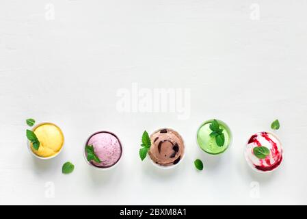 Ensemble de crème glacée. Diverses glaces italiennes sur fond blanc, vue du dessus, espace de copie. Assortiment de yaourts glacés ou de crèmes glacées en tasses - été sain d Banque D'Images