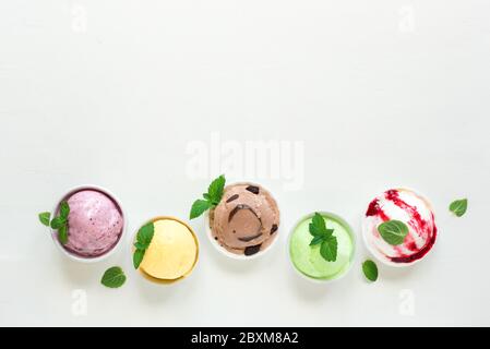 Assortiment de crèmes glacées. Diverses glaces italiennes en rangée sur fond blanc, vue du dessus, espace de copie. Yaourt glacé ou crème glacée en tasses - sain s Banque D'Images