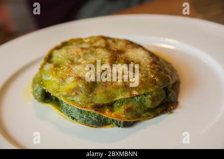 Un gros morceau de raviolis traditionnels italiens Ricotta et épinards, servi dans une assiette blanche Banque D'Images