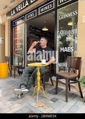 Premia de Mar, Espagne. 07e juin 2020. Adrian Caricart est assis devant son bar à vins « la Vella Lleteria » dans la petite ville côtière de premia de Mar près de Barcelone. Il a encore le temps de se faire plaisir avec un verre de vin rouge de la région de Penedes au-dessus de Barcelone. Après près de trois mois de fermeture forcée pendant la crise de Corona, le propriétaire espère que la prochaine saison des fêtes assurera au moins sa survie économique. (À dpa 'vacances en Espagne 2020: Été, soleil, plage et masque de protection') crédit: Jan-Uwe Ronneburger/dpa/Alay Live News Banque D'Images