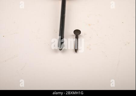 Visser et visser le tournevis sur un fond blanc. Gros plan. Serrurier manuel et outils d'installation pour le travail à domicile Banque D'Images