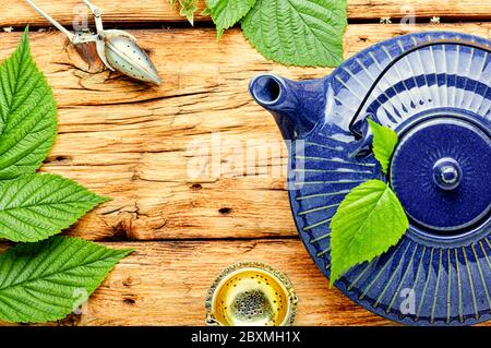 Tisane curative à base de feuilles de framboise fraîches. Théière en verre avec tisane Banque D'Images