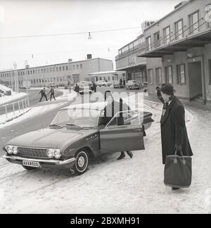 Couple dans les années 1960. Une femme a conduit son mari à l'aéroport et l'a déferé de sa voiture, un modèle spécial 1961 de Buick. C'est une journée d'hiver à l'aéroport de Bromma à Stockholm. Suède 1961. Kristoffersson réf. CS5-4 Banque D'Images