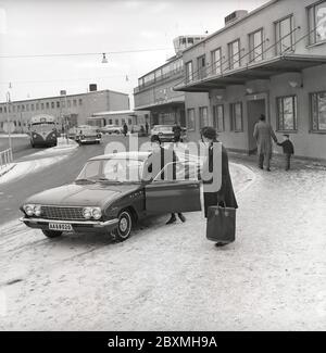 Couple dans les années 1960. Une femme a conduit son mari à l'aéroport et l'a déferé de sa voiture, un modèle spécial 1961 de Buick. C'est une journée d'hiver à l'aéroport de Bromma à Stockholm. Suède 1961. Kristoffersson réf. CS5-1 Banque D'Images