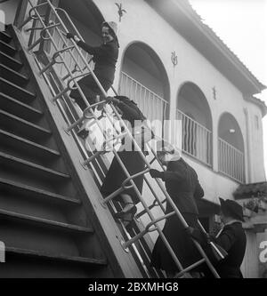 Parc d'attractions dans les années 1950. Peu importe le jeune ou le vieux, tout le monde peut profiter d'un bon amusement dans un parc d'attractions. Photo d'un groupe de femmes essayant de monter les marches d'un escalier en mouvement. Suède 1950. Kristoffersson réf. AY58-7 Banque D'Images