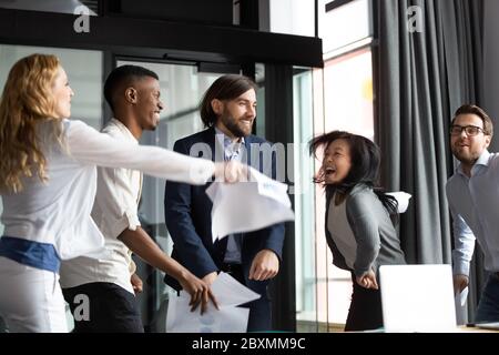 Le personnel multiracial criait avec joie en dansant en s'amusant sur le lieu de travail Banque D'Images