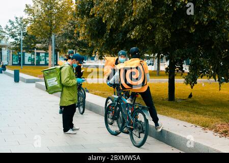 Les porte-aliments à emporter sur un vélo et des coursiers avec une boîte à nourriture isolée se promo rapidement. Livraison express de nourriture des cafés et restaurants. Mosc Banque D'Images