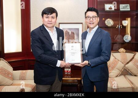 Au nom de l'Association chinoise de football, le secrétaire en chef de la CFA Liu Yi, à droite, confie le professeur Zhang Wenhong de l'hôpital de Huashan, à gauche, sur la lettre de nomination, Shanghai, Chine, 8 juin 2020. L'Association chinoise de football invite le professeur Ma Xin, le professeur Zhang Wenhong et le professeur Wang Huiying de l'hôpital Huashan à être les consultants en prévention des épidémies pour s'assurer que tous les niveaux de matchs de football en Chine puissent reprendre dès que possible. Banque D'Images