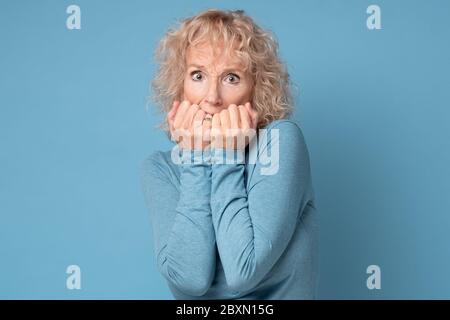 Une femme blonde âgée inquiète se sent désespérée ou effrayée Banque D'Images