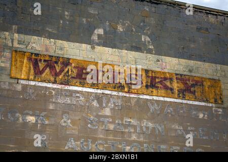 Old rusty whiskey signe à Oamaru dans l'île du sud de Nouvelle-Zélande. Omaru est le foyer de la punk à vapeur. Banque D'Images