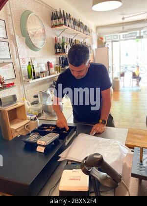 Premia de Mar, Espagne. 07e juin 2020. Le propriétaire Adrian Caricart donne le changement de la till de son bar à vin "la Vella Lleteria" dans la petite ville côtière de premia de Mar près de Barcelone. Il estime la perte à environ 30,000 euros due aux presque trois mois de fermeture forcée pendant la crise de Corona. Crédit : Jan-Uwe Ronneburger/dpa/Alay Live News Banque D'Images