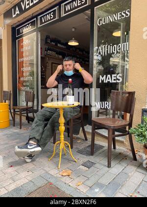 Premia de Mar, Espagne. 07e juin 2020. Adrian Caricart est assis devant son bar à vins « la Vella Lleteria » dans la petite ville côtière de premia de Mar près de Barcelone. Il a encore le temps de se faire plaisir avec un verre de vin rouge de la région de Penedes au-dessus de Barcelone. Après près de trois mois de fermeture forcée pendant la crise de Corona, le propriétaire espère que la prochaine saison des fêtes assurera au moins sa survie économique. Crédit : Jan-Uwe Ronneburger/dpa/Alay Live News Banque D'Images