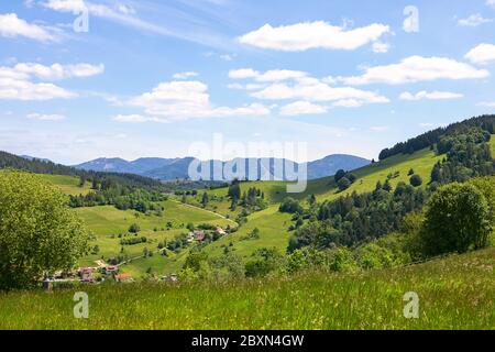 Paysage idyllique, vue sur les montagnes Schwarzwald, printemps. Collines avec le village dans la vallée, maisons, prés et forêt. Panorama sur la Forêt-Noire Banque D'Images