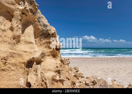 Vue sur les eaux turquoise de la mer Méditerranée à travers les formations de sable sur la rive contre le ciel bleu Banque D'Images