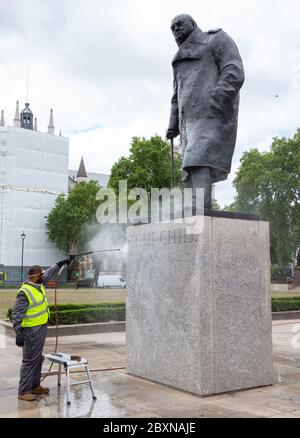 Londres, Royaume-Uni. 8 juin 2020. Des ouvriers nettoient la statue de Winston Churchill sur la place du Parlement, à Londres. Des graffitis ont été pulvérisés sur la plinthe lors du rassemblement « Black Lives Matter » qui s'est tenu le week-end. Credit: Tommy London/Alay Live News Banque D'Images