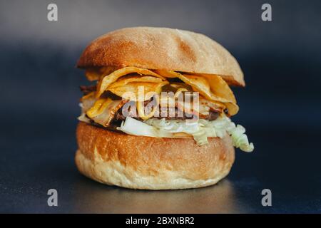 Circulaire Burger. Hamburger au fromage avec viande grillée, fromage, salade et rondelles d'oignon. Gros plan de délicieux hamburgers maison frais sur fond bleu écorce Banque D'Images