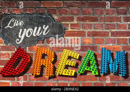 Les mots Live Your Dream écrits sur un mur de brique rouge Banque D'Images