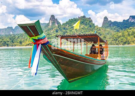 Bateau traditionnel thaïlandais à longue queue en bois sur le lac Cheyouw LAN, barrage de Ratchapapha, parc national de Khao Sok en Thaïlande en été Banque D'Images