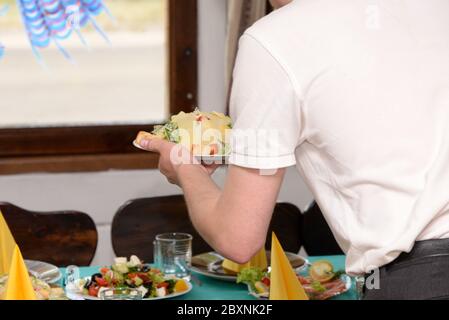 Le serveur sert une salade sur la table de fête Banque D'Images