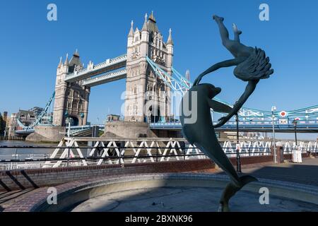 La fille avec un dauphin sur la rive nord de la Tamise avec une vue sur Tower Bridge lors d'une belle journée ensoleillée de printemps à Londres. ROYAUME-UNI. Banque D'Images