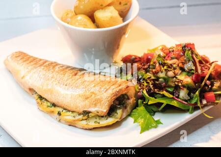 Bar de mer entier cuit avec de nouvelles pommes de terre Banque D'Images