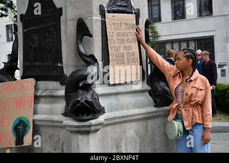 Asha (nom de famille non donné), 25 ans, de Bristol place son dévouement sur la plinthe vide où la statue d'Edward Colston à Bristol était autrefois debout après qu'elle ait été prise lors d'une manifestation Black Lives Matter dimanche. Les manifestations ont été déclenchées par la mort de George Floyd, qui a été tué le 25 mai alors qu'il était en garde à vue dans la ville américaine de Minneapolis. Banque D'Images