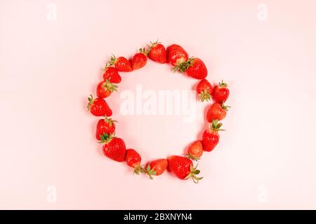 Cadre fait de fraises en cercle sur fond de rose Banque D'Images