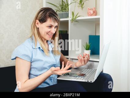 Femme utilisant un ordinateur portable pour les appels vidéo à la maison. Vidéoconférence en ligne Banque D'Images