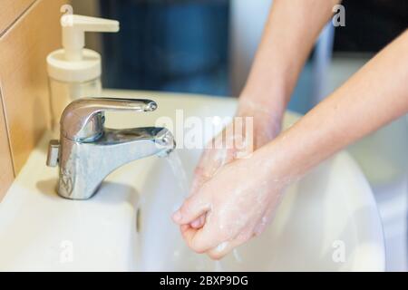 Se laver les mains avec du savon sous le robinet avec de l'eau . Concept d'hygiène. Banque D'Images