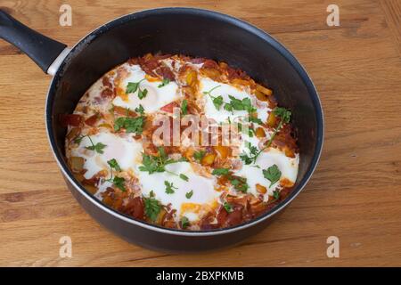 Un plat égyptien Shakshuka, des œufs pochés dans une sauce tomate et poivre Banque D'Images
