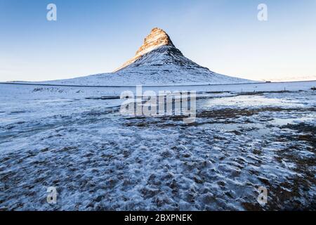 Kirkjufell vue pendant la neige d'hiver qui est une haute montagne sur la côte nord de la péninsule de Snaefellsnes en Islande, près de la ville de Grundarfjordur Banque D'Images