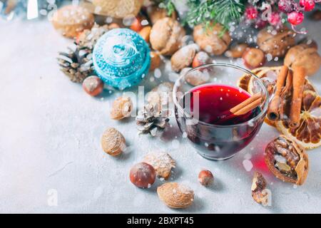 Composition de Noël. Verre de vin rouge chaud sur table avec bâtonnets de cannelle, décorations de Noël. Mise au point sélective Banque D'Images