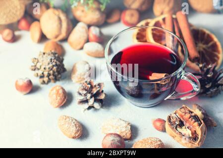 Composition de Noël. Verre de vin rouge chaud sur table avec bâtonnets de cannelle, décorations de Noël. Mise au point sélective Banque D'Images