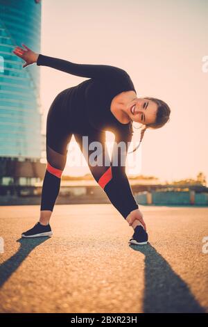 Femme positive faisant un exercice de forme physique en extérieur Banque D'Images