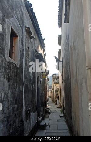 Ancienne ville de Xidi dans la province d'Anhui, Chine. Un petit chemin dans la vieille ville de Xidi avec des bâtiments historiques, chemin de pierre de drapeau et murs sombres Banque D'Images