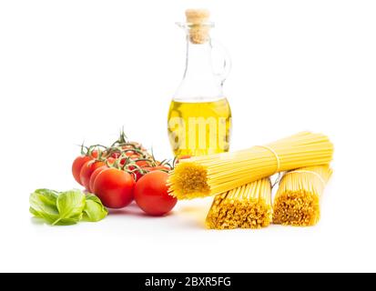 Pâtes spaghetti crues, tomates cerises, feuilles de basilic et huile d'olive isolées sur fond blanc. Banque D'Images