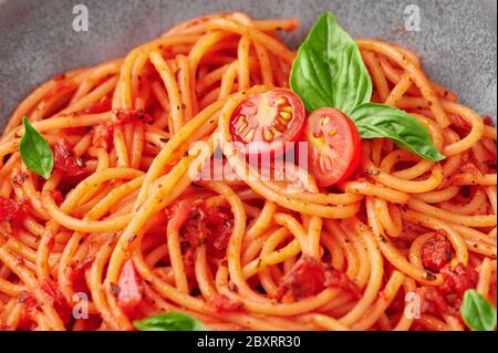 Spaghetti de tomate dans un bol gris. Les pâtes à la sauce tomate sont des plats de cuisine italienne classiques. Cuisine italienne populaire. Gros plan Banque D'Images