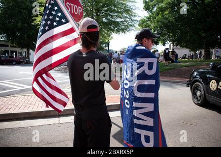 Jasper, Géorgie, États-Unis. 7 juin 2020. Les manifestants de Black Lives Matter se rassemblent à l'extérieur du palais de justice du comté de Pickens, dans la région rurale du nord de la Géorgie, pour protester contre la brutalité policière contre les minorités. Ils ont été accueillis par des contre-manifestants conservateurs et des partisans du président Trump qui ont assisté au rassemblement de l'autre côté de la rue principale de townÃs. Photo : les élèves du secondaire qui prévoient voter en novembre brandifient les drapeaux pour soutenir le président Trump alors que les voitures passent dans la rue principale de townÃs. Crédit : Robin Rayne/ZUMA Wire/Alay Live News Banque D'Images