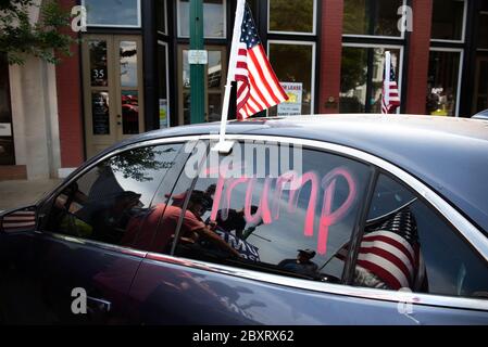 Jasper, Géorgie, États-Unis. 7 juin 2020. Les manifestants de Black Lives Matter se rassemblent à l'extérieur du palais de justice du comté de Pickens, dans la région rurale du nord de la Géorgie, pour protester contre la brutalité policière contre les minorités. Ils ont été accueillis par des contre-manifestants conservateurs et des partisans du président Trump qui ont assisté au rassemblement de l'autre côté de la rue principale de townÃs. Photo : les élèves du secondaire qui prévoient voter en novembre brandifient les drapeaux pour soutenir le président Trump alors que les voitures passent dans la rue principale de townÃs. Crédit : Robin Rayne/ZUMA Wire/Alay Live News Banque D'Images
