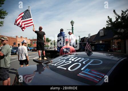 Jasper, Géorgie, États-Unis. 7 juin 2020. Les manifestants de Black Lives Matter se rassemblent à l'extérieur du palais de justice du comté de Pickens, dans la région rurale du nord de la Géorgie, pour protester contre la brutalité policière contre les minorités. Ils ont été accueillis par des contre-manifestants conservateurs et des partisans du président Trump qui ont assisté au rassemblement de l'autre côté de la rue principale de townÃs. Photo : les élèves du secondaire qui prévoient voter en novembre brandifient les drapeaux pour soutenir le président Trump alors que les voitures passent dans la rue principale de townÃs. Crédit : Robin Rayne/ZUMA Wire/Alay Live News Banque D'Images