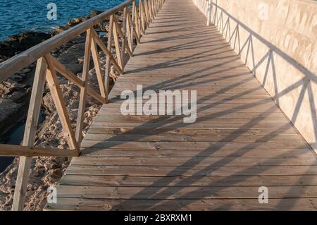 Promenade en bois sur la mer Méditerranée au coucher du soleil Banque D'Images