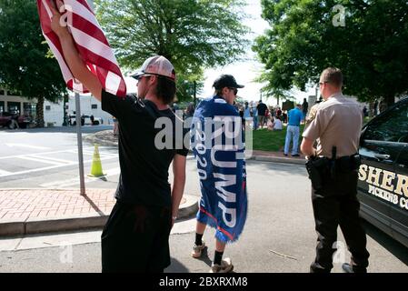 Jasper, Géorgie, États-Unis. 7 juin 2020. Les manifestants de Black Lives Matter se rassemblent à l'extérieur du palais de justice du comté de Pickens, dans la région rurale du nord de la Géorgie, pour protester contre la brutalité policière contre les minorités. Ils ont été accueillis par des contre-manifestants conservateurs et des partisans du président Trump qui ont assisté au rassemblement de l'autre côté de la rue principale de townÃs. Photo : les élèves du secondaire qui prévoient voter en novembre brandifient les drapeaux pour soutenir le président Trump alors que les voitures passent dans la rue principale de townÃs. Crédit : Robin Rayne/ZUMA Wire/Alay Live News Banque D'Images