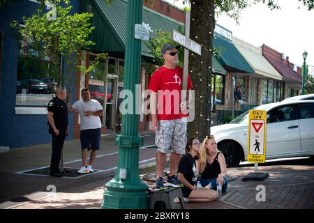Jasper, Géorgie, États-Unis. 7 juin 2020. Les manifestants de Black Lives Matter se rassemblent à l'extérieur du palais de justice du comté de Pickens, dans la région rurale du nord de la Géorgie, pour protester contre la brutalité policière contre les minorités. Ils ont été accueillis par des contre-manifestants conservateurs et des partisans du président Trump qui ont assisté au rassemblement de l'autre côté de la rue principale de townÃs. Photo : un évangéliste et des résidents locaux regardent le rallye d'un pick-up de l'autre côté de la rue crédit : Robin Rayne/ZUMA Wire/Alamy Live News Banque D'Images