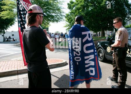 Jasper, Géorgie, États-Unis. 7 juin 2020. Les manifestants de Black Lives Matter se rassemblent à l'extérieur du palais de justice du comté de Pickens, dans la région rurale du nord de la Géorgie, pour protester contre la brutalité policière contre les minorités. Ils ont été accueillis par des contre-manifestants conservateurs et des partisans du président Trump qui ont assisté au rassemblement de l'autre côté de la rue principale de townÃs. Photo : les élèves du secondaire qui prévoient voter en novembre brandifient les drapeaux pour soutenir le président Trump alors que les voitures passent dans la rue principale de townÃs. Crédit : Robin Rayne/ZUMA Wire/Alay Live News Banque D'Images