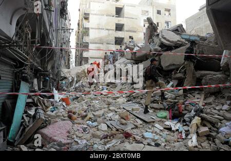 Les responsables de la sécurité ont enfermé dimanche le site de l'incident d'effondrement d'un immeuble résidentiel de six étages alors que l'opération de sauvetage est en cours, situé sur la colonie Liaquat Lyari à Karachi, le lundi 8 juin 2020. Un immeuble résidentiel de six étages s'est effondré dans le marché de Khasda de Lyari, dimanche soir. Quatre corps ont été retirés sous les débris - deux hommes et deux femmes - et 12 personnes ont été blessées lors de l'incident, selon les secouristes.On pense qu'il y avait environ 50 à 60 personnes dans le bâtiment au moment de l'effondrement. Banque D'Images