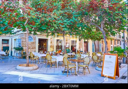 CADIX, ESPAGNE - 23 SEPTEMBRE 2019: La terrasse extérieure du restaurant avec de petites tables sous les arbres ombragés de la rue Calle Pocia dans la vieille de Banque D'Images