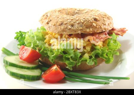 Bagel avec œufs brouillés et bacon Banque D'Images